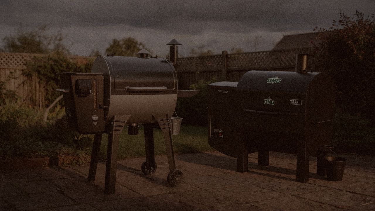 Camp Chef Woodwind Pro WiFi 24 and Green Mountain Grills Trek at night with smoke, wood pellet grills on a dark patio