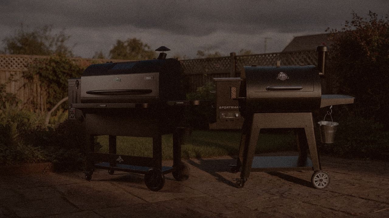 Green Mountain Grills Peak and Pit Boss Sportsman at night with smoke, wood pellet grills on a dark patio
