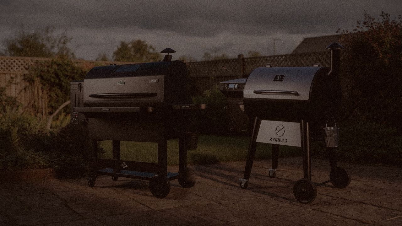 Green Mountain Grills Peak and Z Grills 700 Series (ZPG-7002) at night with smoke, wood pellet grills on a dark patio