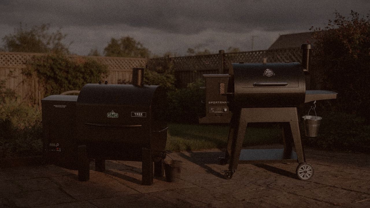 Green Mountain Grills Trek and Pit Boss Navigator 850 at night with smoke, wood pellet grills on a dark patio