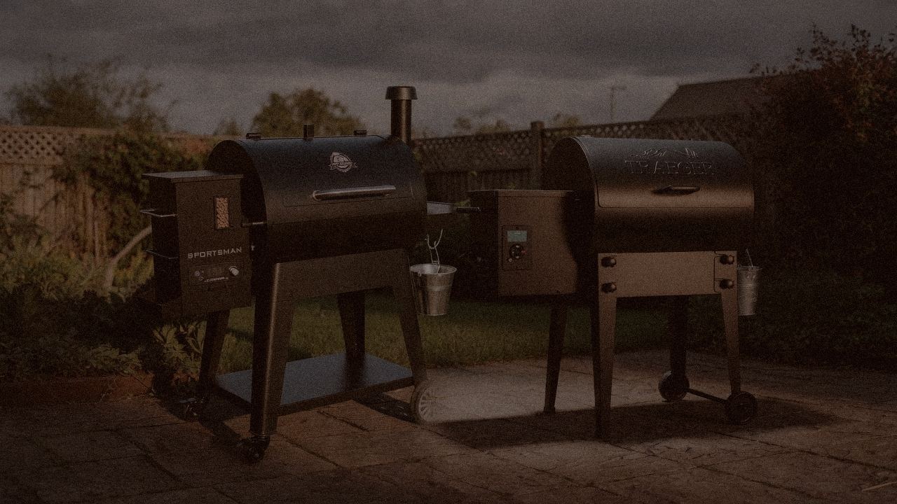 Pit Boss Navigator 850 and Traeger Tailgater 20 at night with smoke, wood pellet grills on a dark patio