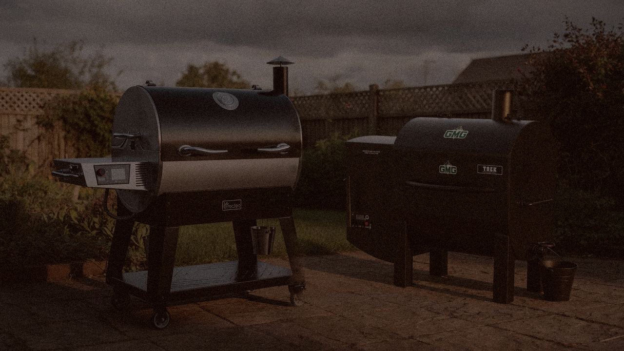 recteq Flagship 1600 and Green Mountain Grills Trek at night with smoke, wood pellet grills on a dark patio