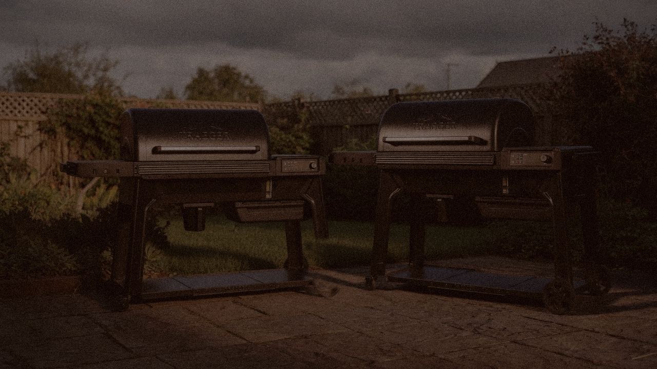Traeger Ironwood and Traeger Pro 780 at night with smoke, wood pellet grills on a dark patio