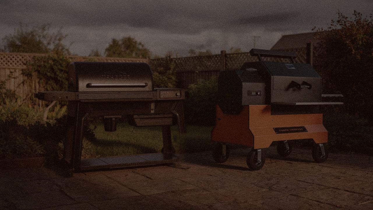 Traeger Ironwood and Yoder Smokers YS640s at night with smoke, wood pellet grills on a dark patio
