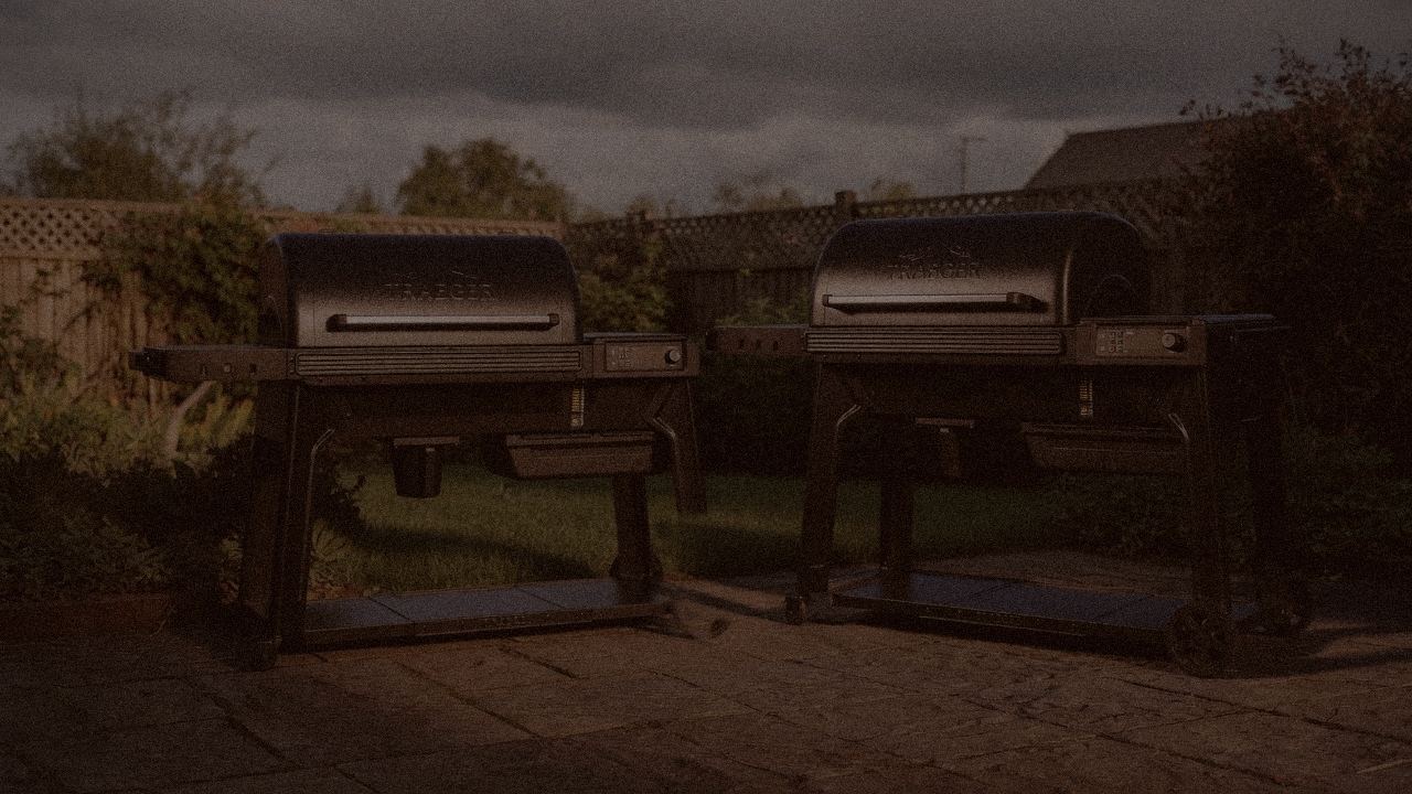 Traeger Pro 780 and Traeger Timberline at night with smoke, wood pellet grills on a dark patio