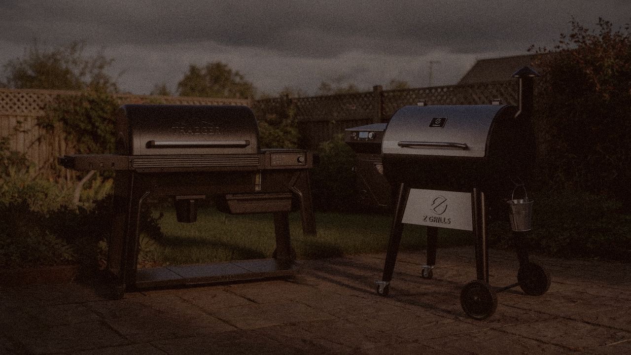 Traeger Pro 780 and Z Grills 700 Series (ZPG-7002) at night with smoke, wood pellet grills on a dark patio