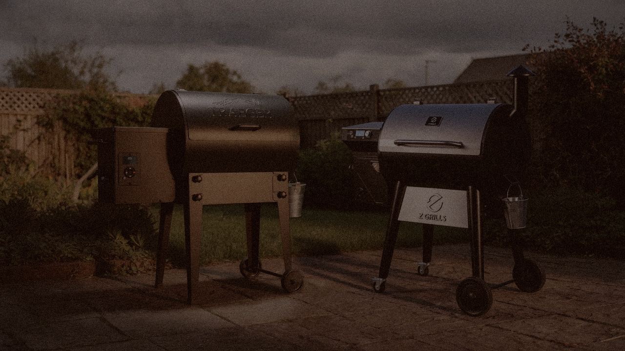 Traeger Tailgater 20 and Z Grills 700 Series (ZPG-7002) at night with smoke, wood pellet grills on a dark patio