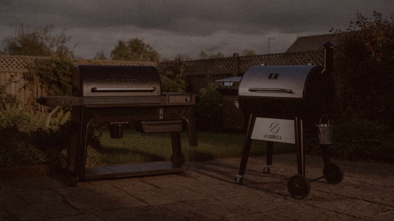 Traeger Timberline and Z Grills 700 Series (ZPG-7002) at night with smoke, wood pellet grills on a dark patio