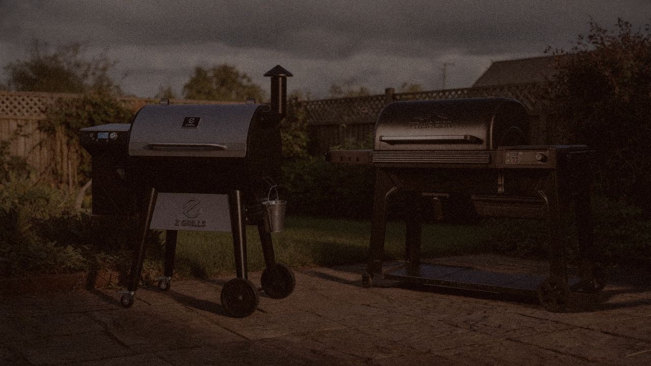 Z Grills 700 Series beside Traeger Woodridge Pro, official product photography on a dark steel panel